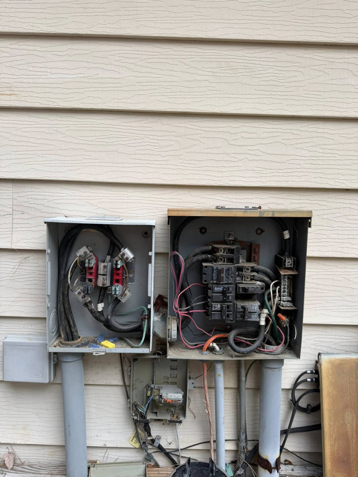 Two residential outdoor electrical panels with open covers, showing wiring by Power Tech Electrical Services in Durham, NC.