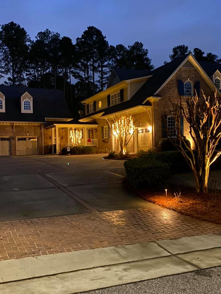 Residential outdoor and landscape lighting illuminating a house at dusk by Pierce Electric, LLC in Fayetteville, NC