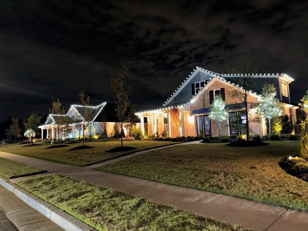 Beautiful residential outdoor lighting installation illuminating two homes at night by Precision Electric and Lighting Services in Olive Branch, MS.