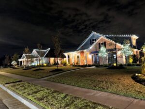 Beautiful residential outdoor lighting installation illuminating two homes at night by Precision Electric and Lighting Services in Olive Branch, MS.