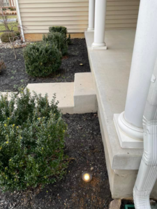 A residential outdoor pathway light installed near a porch by K E Troutman Electrical Contractor in Newark, DE.