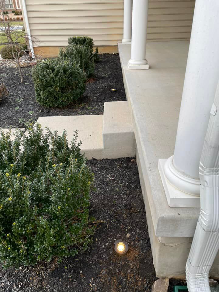 A residential outdoor pathway light installed near a porch by K E Troutman Electrical Contractor in Newark, DE.