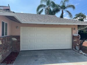 Exterior view of a light-colored paneled garage door on a residential home by BSD Garage Door in Naperville, IL