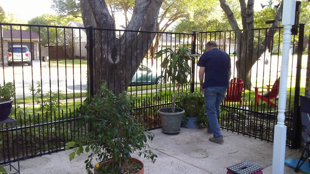 A residential patio area secured with a black metal fence installed by Dallas Mobile Welder, LLC. in Dallas, TX.