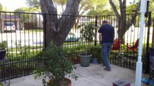 A residential patio area secured with a black metal fence installed by Dallas Mobile Welder, LLC. in Dallas, TX.