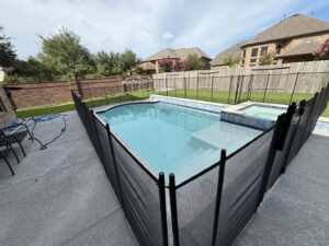 A completed residential pool fence project featuring a black mesh barrier by Lone Star Pool Fence in Houston, TX.