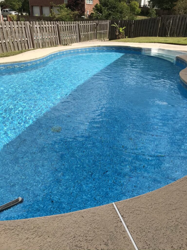A residential swimming pool with leaves and debris on the bottom that needs cleaning by Fenix Pool and Spa LLC in Summerville, SC.