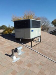 A residential rooftop HVAC unit on a shingle roof, maintained by Otto's Air Conditioning & Heating in Mesa, AZ.