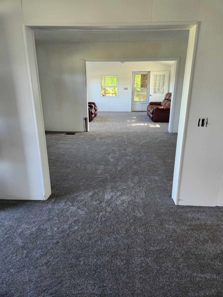 A residential room with newly installed grey carpet by PerfectStep Flooring Solutions in Rochester, NY.