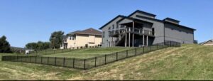 A black ornamental metal fence installed along a sloped residential backyard by The GateKeeper Perimeter Fence & Automated Security in Sioux Falls, SD
