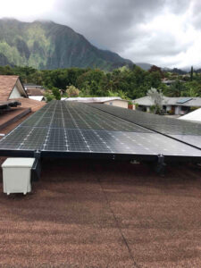Residential solar panel installation by Alternate Energy Inc. on a roof in Pearl City, HI, with mountains in the background.