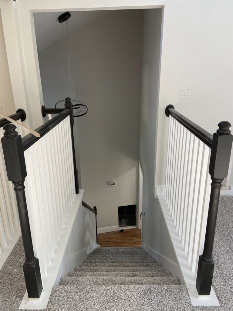 View looking down a residential staircase with newly installed gray carpet by Castro's Carpet in Houston, TX.