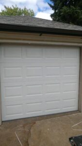 A newly installed white paneled residential garage door on a home by Xpress Doors LLC in Salem, OR