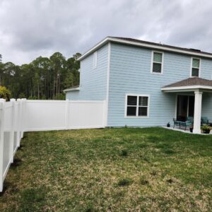 A residential property featuring a new white vinyl privacy fence, providing security and curb appeal from Exacta FENCE LLC in Jacksonville, FL.