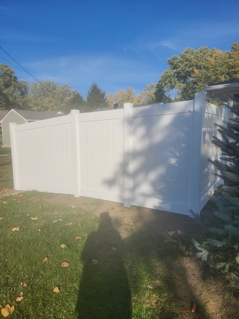 Residential white vinyl fence installation providing privacy in a backyard by Cameron Fence Builders in Indianapolis, IN.