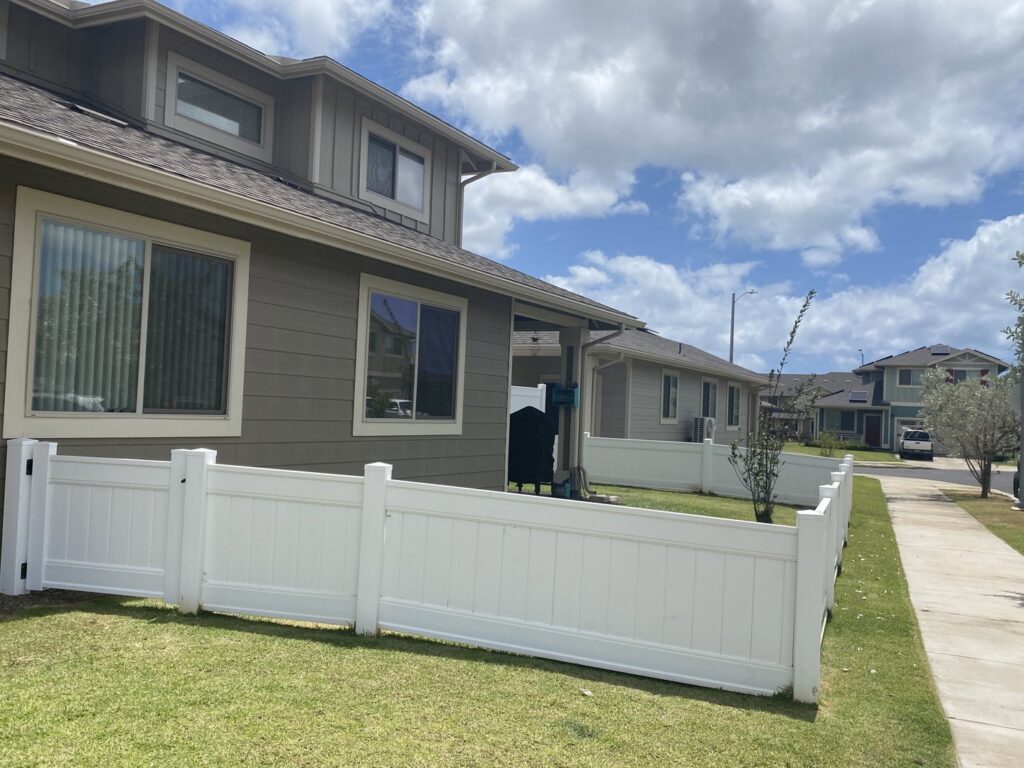 A white vinyl fence installed between residential properties by Redmond Valleywide - Hawaii's Fence Company in Kapolei, HI