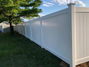 A clean white vinyl privacy fence enclosing a residential yard, installed by Zelaya Fence in New York City, NY.