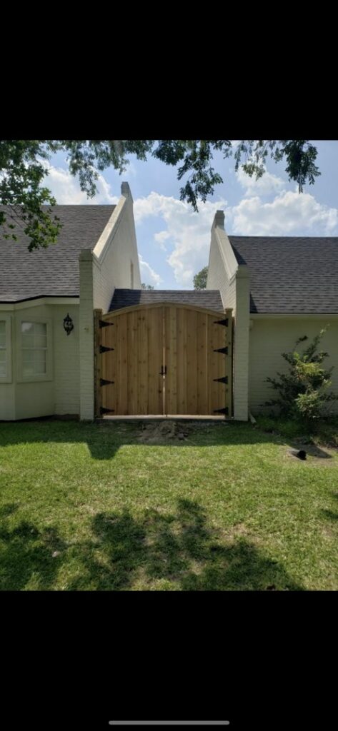 A residential wood double gate installed in front of a house by A-1 Security Fence in Scott, LA.