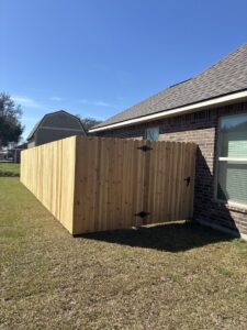 A new residential wood privacy fence with a matching gate, installed by 985 Fence, LLC in Schriever, LA.