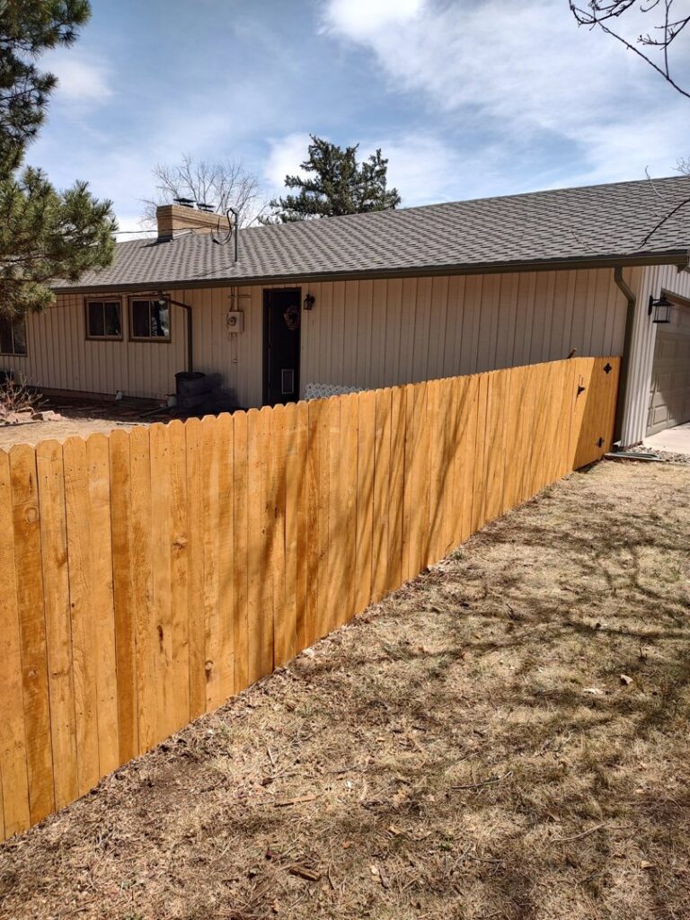 A newly installed residential wood fence along a property line, expertly crafted by Good Neighbor Fencing, LLC in Colorado Springs, CO.