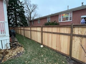 A newly installed wooden privacy fence running alongside a residential home by Rio Fence Co. in Lincoln, NE.
