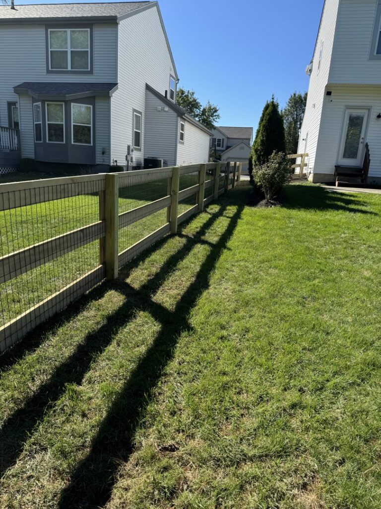 A wood fence with wire mesh installed between residential homes by ReliableFencing in Columbus, OH.