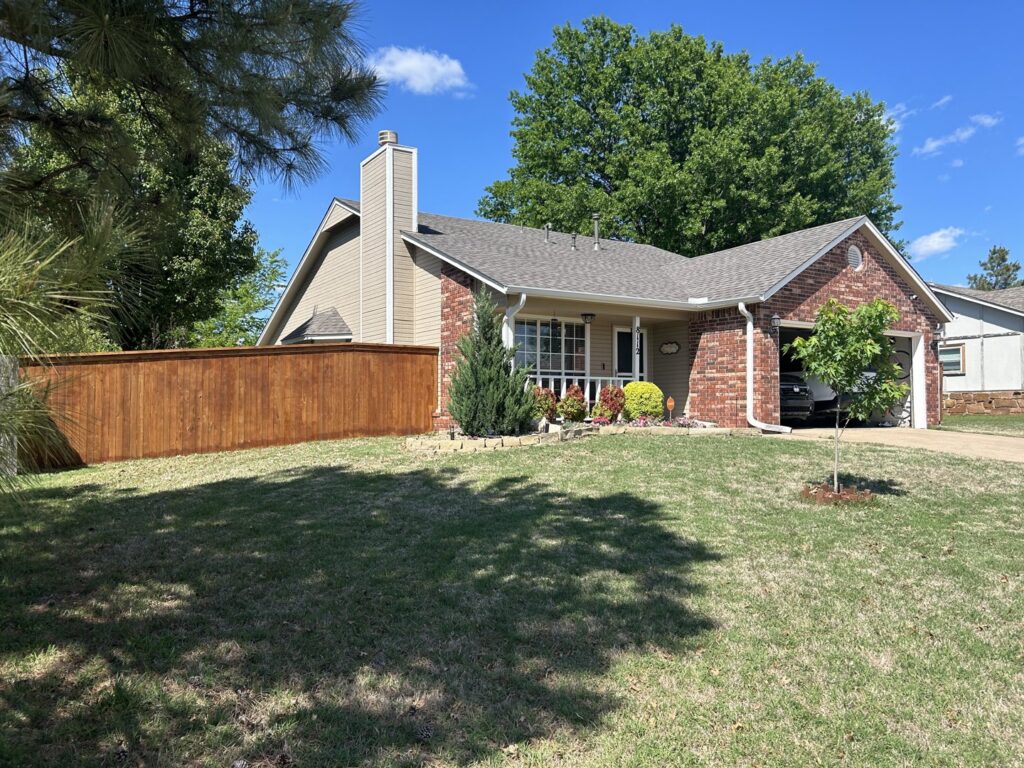 A well-maintained wooden fence enclosing a residential front yard, installed by Ninety-One Services in Tulsa, OK