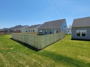 A newly installed wooden picket fence in a residential backyard by Affordable Fence Builders in Dayton, OH.