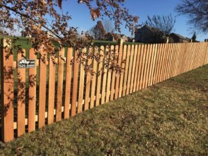 A newly installed residential wooden picket fence by Roy & Son Fencing in Lee's Summit, MO.