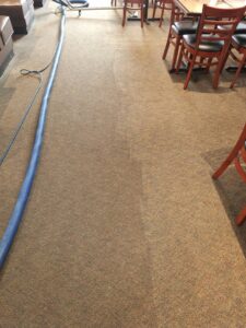 Restaurant carpet cleaning in progress, showing a clear before and after line, by Keith's Cleaning Service in Auburn, ME