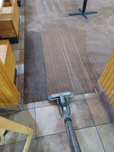Restaurant carpet cleaning in progress, showing clean and dirty sections by Professional Carpet Systems of Raleigh, NC
