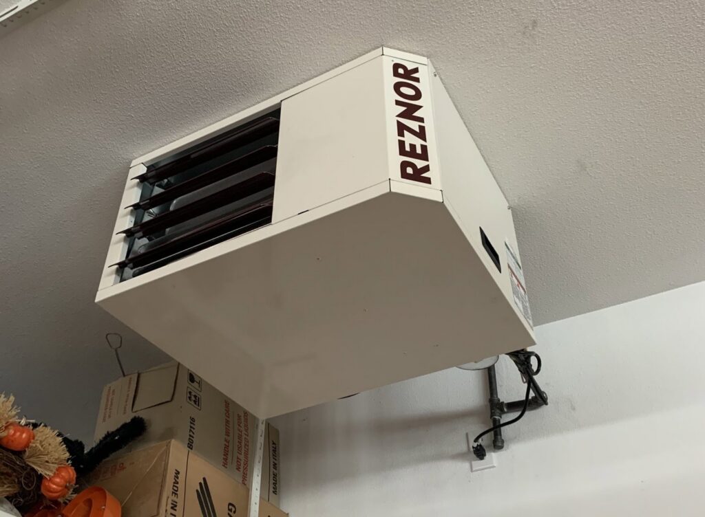A Reznor garage heater installed on a ceiling, representing HVAC heating services by Service Legends in Des Moines, IA.