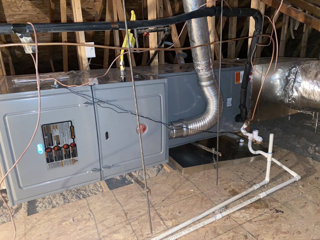 A Rheem air handler unit installed in an attic with ductwork by Kings of AC, LLC in Queen Creek, AZ.
