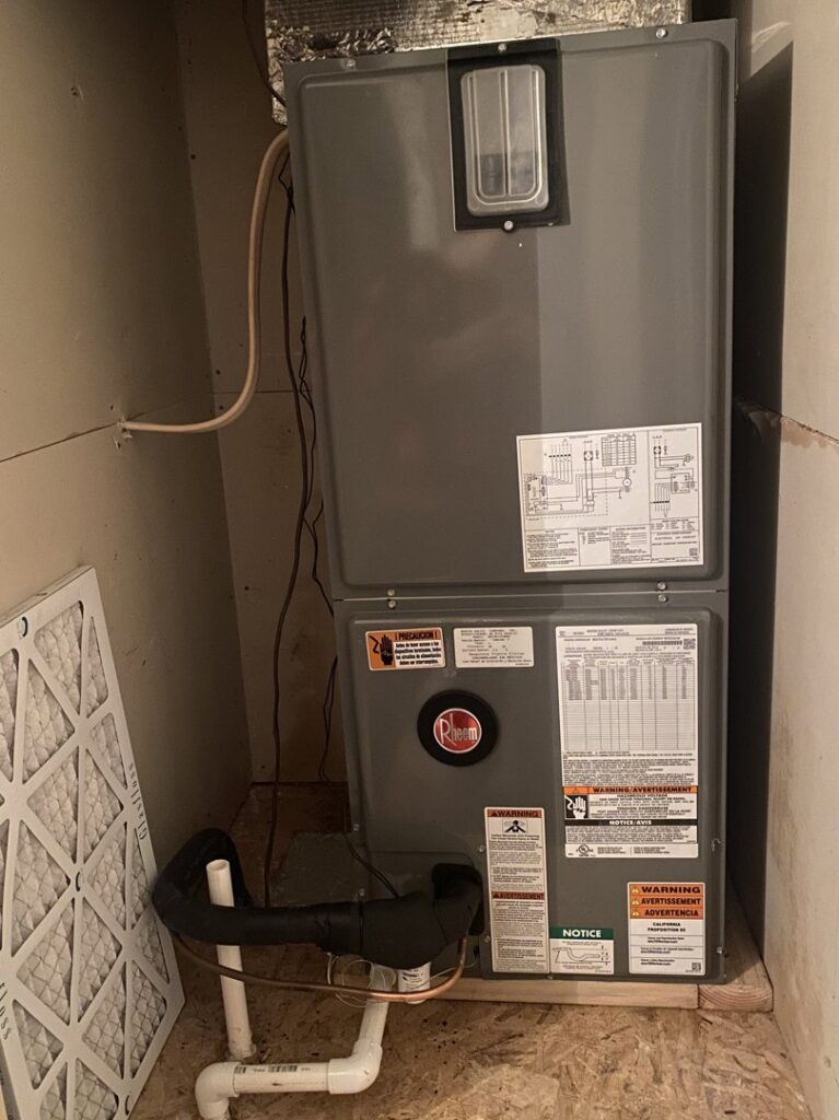 An indoor Rheem furnace and air handler unit with a clean filter nearby from Air Fix in Fayetteville, AR.