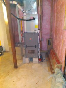 A Rheem furnace and ductwork installed in a basement with pink insulation by Air We Are in Toms River, NJ.