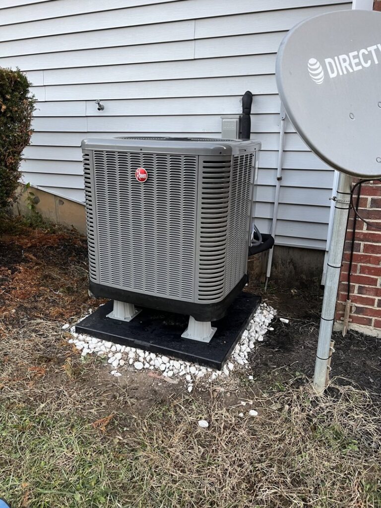 An outdoor Rheem HVAC condenser unit installed next to a residential home by GrinHouse HVACR in La Grange, KY.