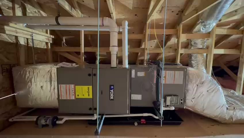 A Rheem HVAC furnace and air handler unit with ductwork installed in a utility room by Fast Air in Zebulon, NC.