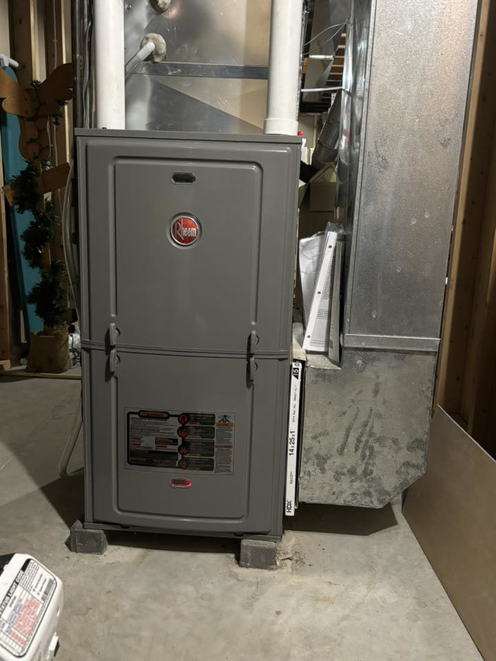 A Rheem indoor furnace unit with ductwork and filter slot, installed by Air Control Heating & Cooling LLC in Schererville, IN.