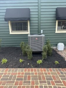 A Rheem outdoor AC unit installed next to a building, showcasing work by Trusted HVAC in Martinsburg, WV