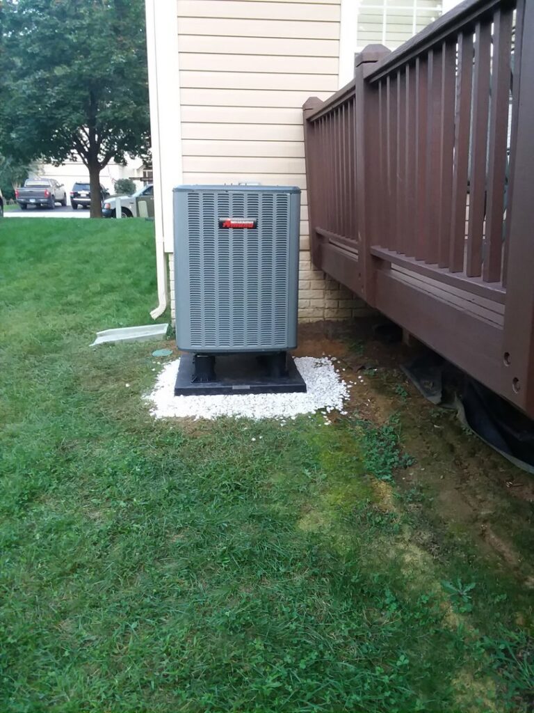 An outdoor Rheem air conditioning unit installed next to a residential deck by Appliance Doctor, Inc. in Annapolis, MD.