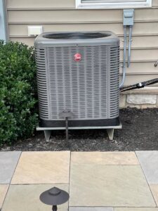 A newly installed Rheem outdoor AC unit next to a residential home by Trusted HVAC in Martinsburg, WV