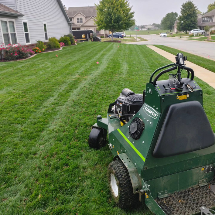 A ride-on lawn aerator working on a residential lawn, providing expert care from Mr. B's Lawn Aeration in Lafayette, IN.