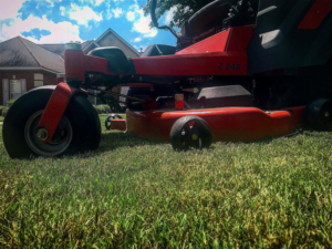 A red riding lawn mower on a well-maintained residential lawn by Thorn Lawn Service in Montgomery, AL.