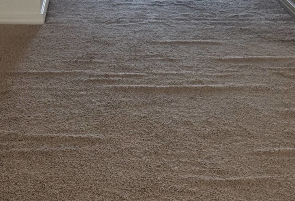 A rippled carpet needing stretching service before repair by The Carpet Medic in Suffolk, VA