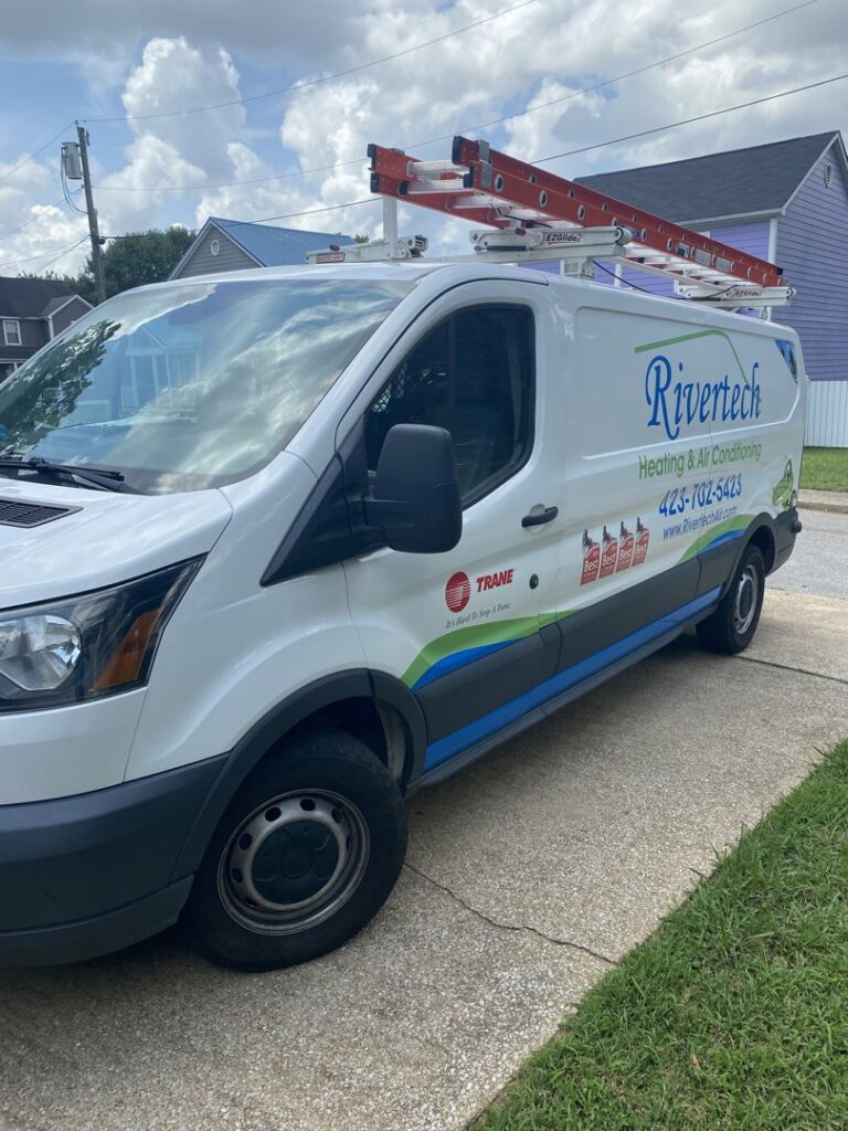 A Rivertech Heating & Air Conditioning service van with ladders on the roof, ready for HVAC jobs in Chattanooga, TN.