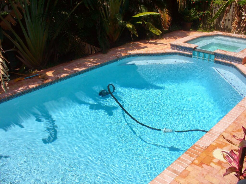 A robotic pool cleaner actively cleaning a residential swimming pool, demonstrating services by Reflections Pool Service Az in Tucson, AZ.
