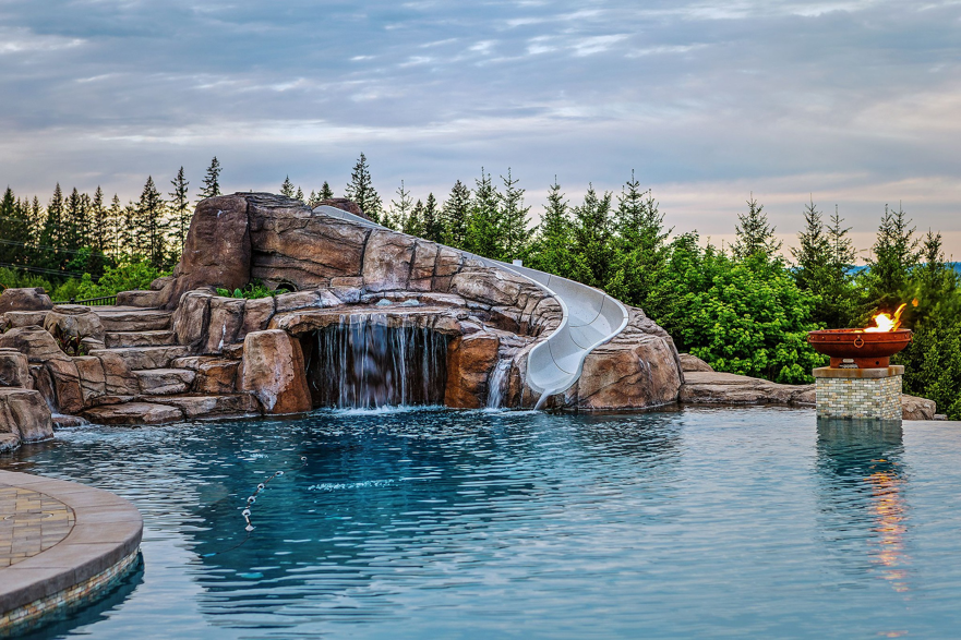 A custom pool featuring a rock waterfall, slide, and fire bowl, built by Anderson Poolworks in Wilsonville, OR.