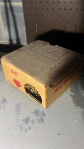 A rodent bait station placed on a floor with paw prints for pest control by Brian's Pest Services in Martinsburg, WV.