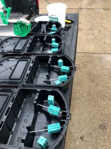 Several rodent bait stations with blue bait blocks, prepared for pest control services by ARC Animal Removal & Control in Cincinnati, OH.