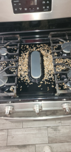 Rodent droppings and debris scattered across a stovetop, indicating a pest issue, addressed by Before and After Pest Control in Kenner, LA.